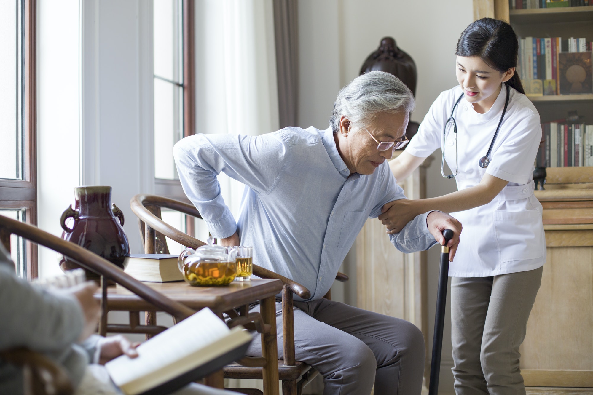 Nursing assistant taking care of senior man