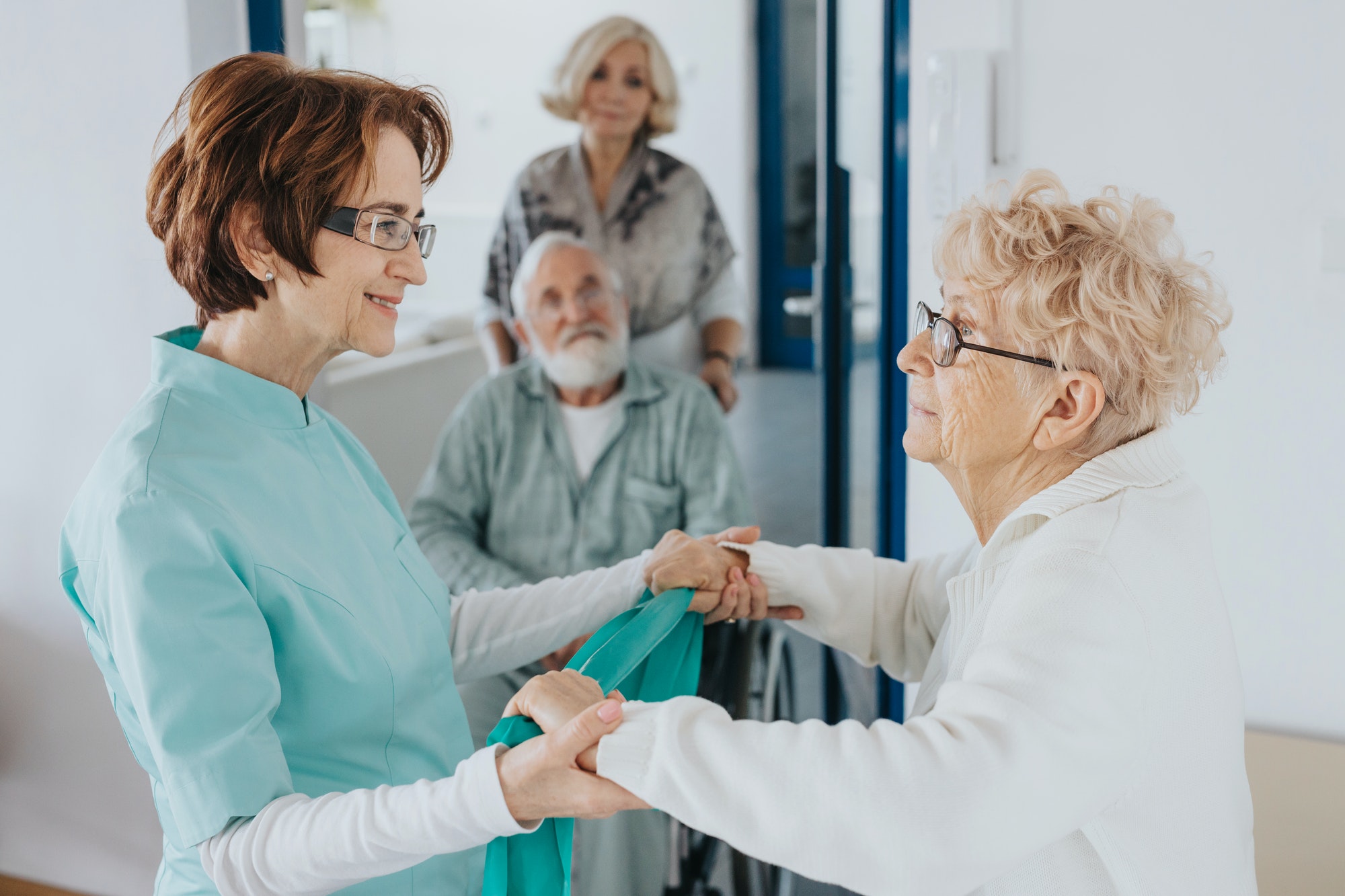 Smiling nurse holds an elderly lady's hands, helping her